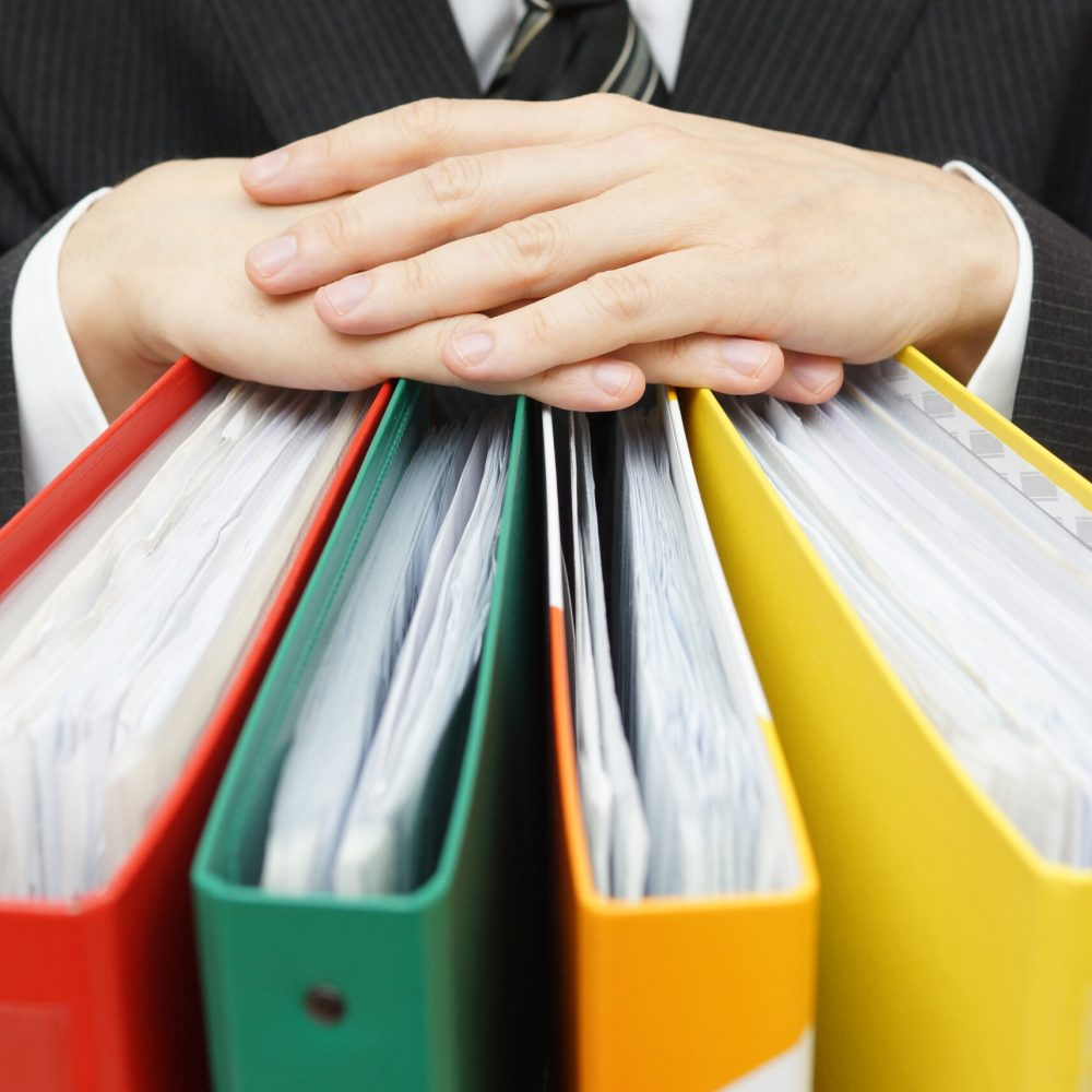 Midsection,Of,Businessman,With,Binders,At,Office